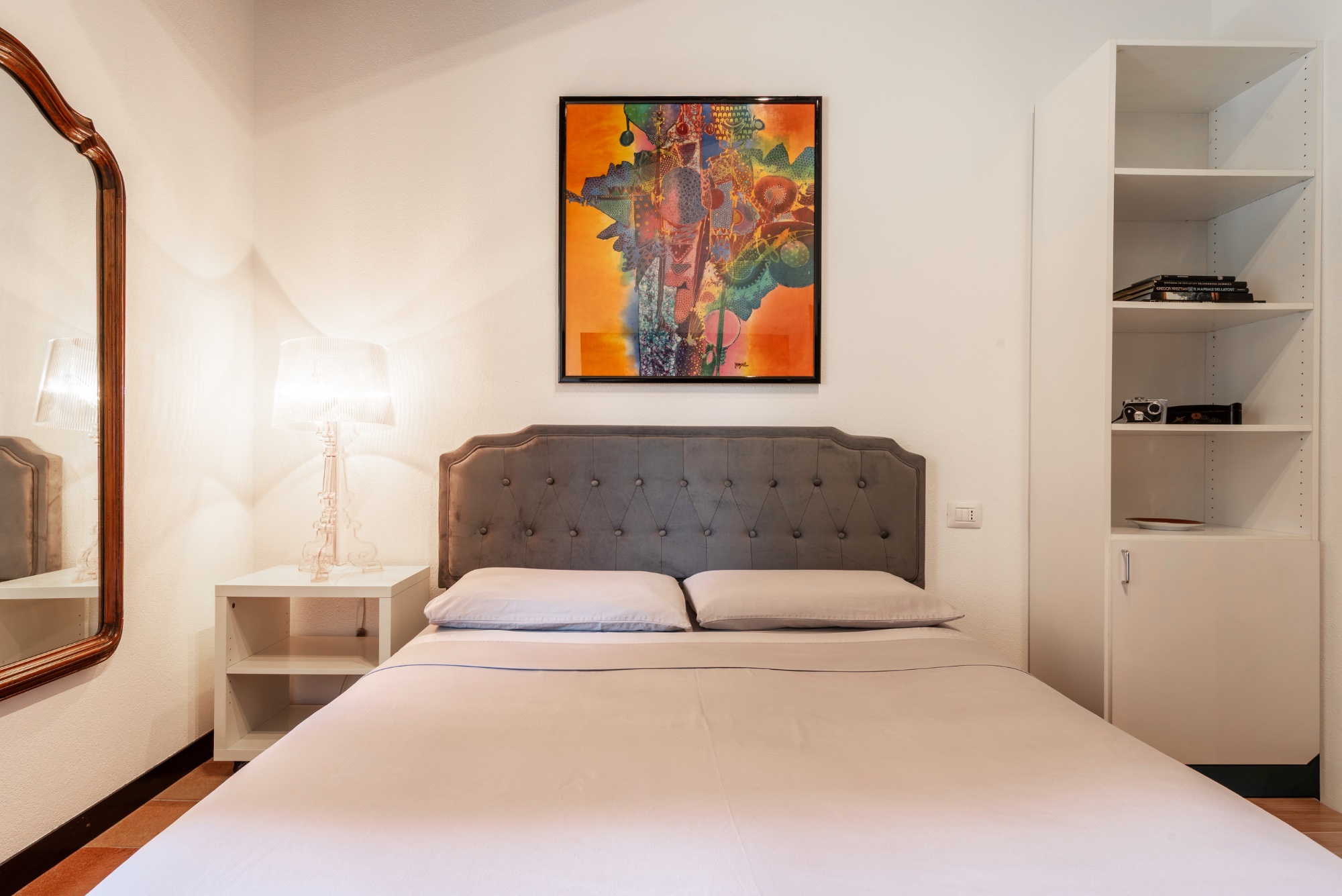The gray bedroom — bed and orange painting