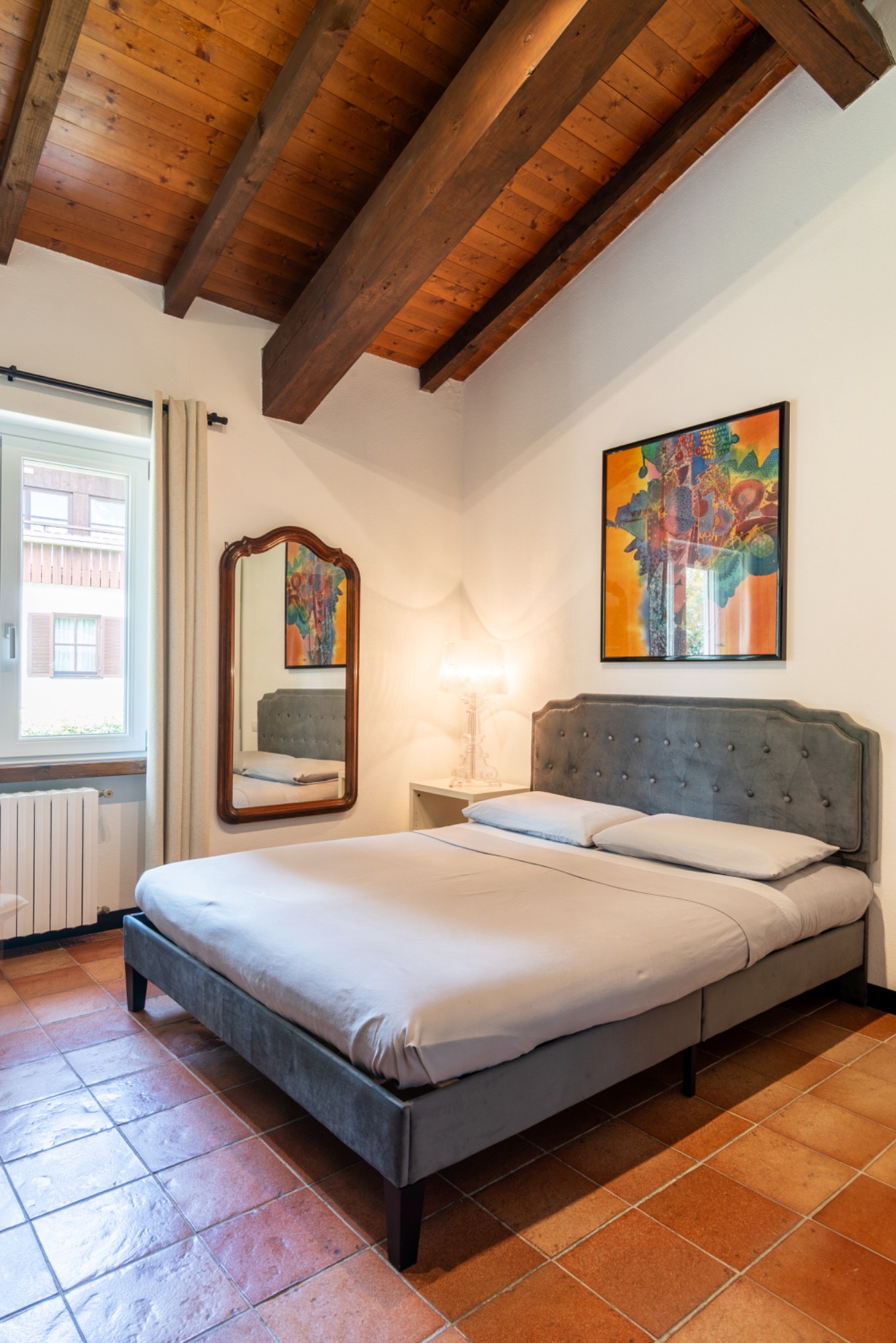The gray bedroom — wide view, mirror and abstract painting