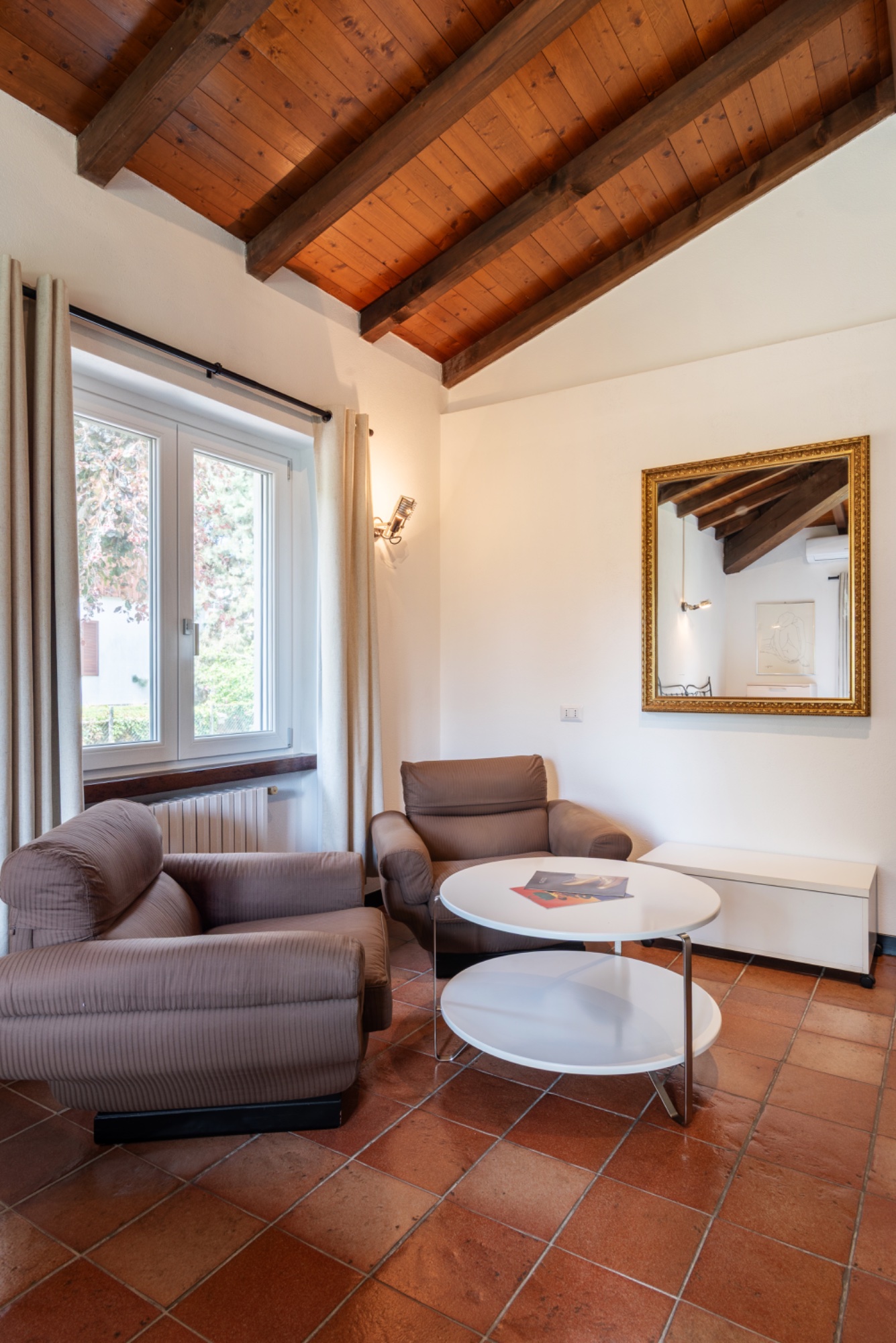 The sitting area — sofas, gold mirror, the corner window
