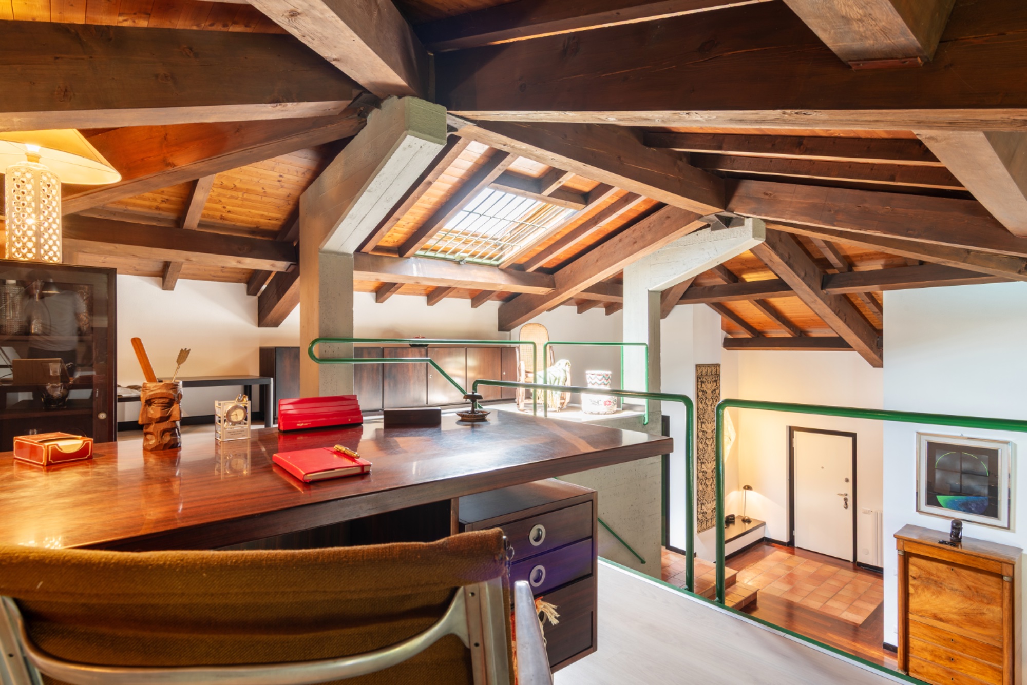 The writer's vantage — desk, beams, skylight, the room