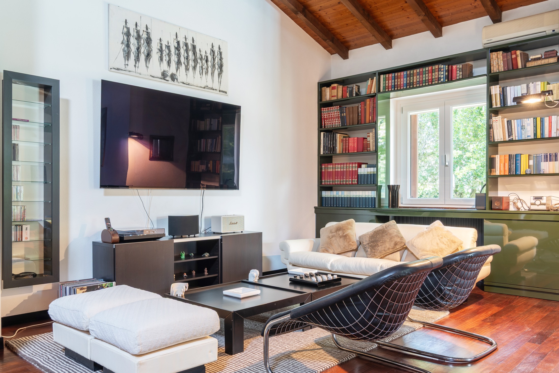 The TV area — sofas, screen, library wall
